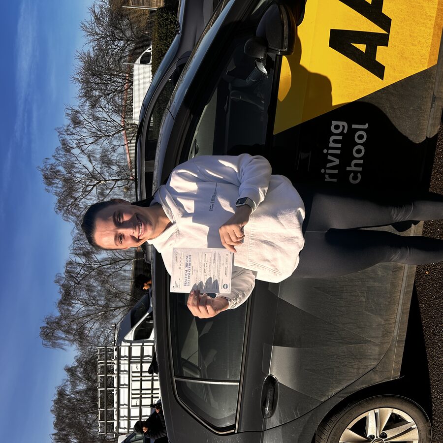 Ebony holding her practical driving test pass certificate