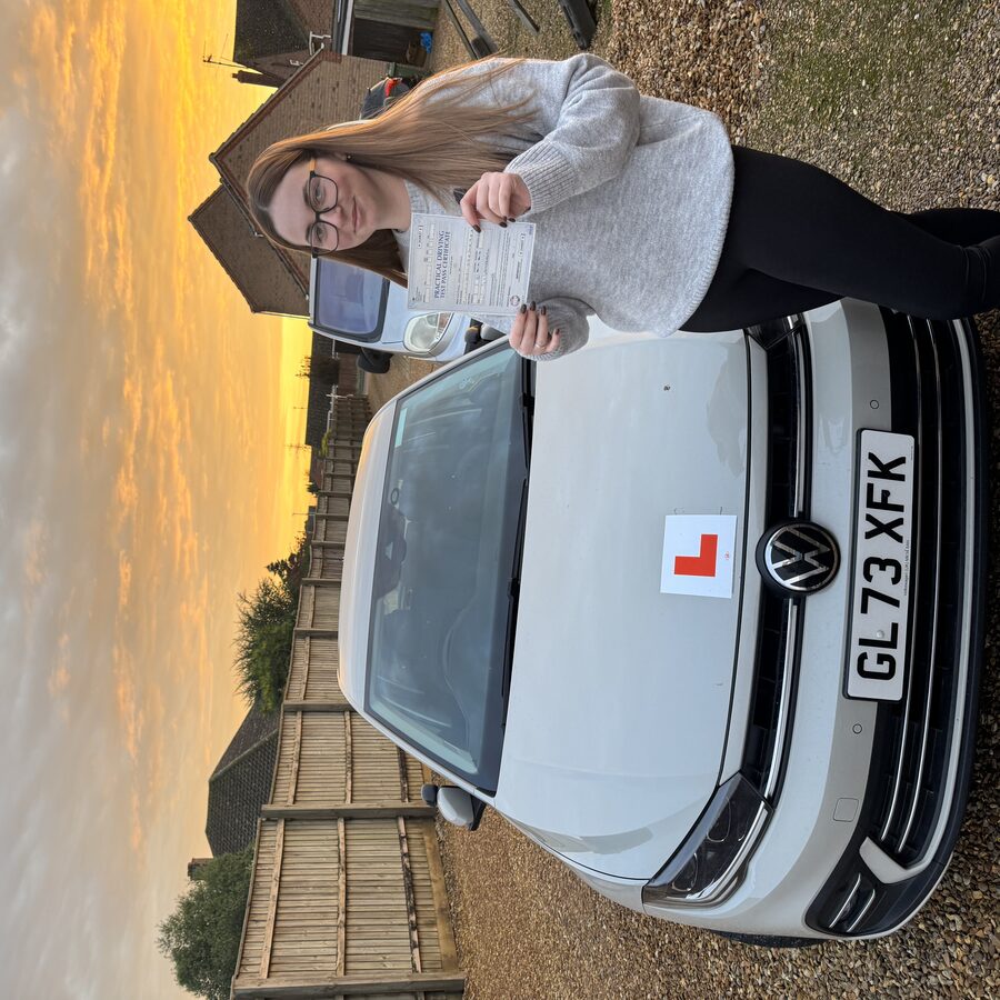 Megan holding her practical driving test pass certificate