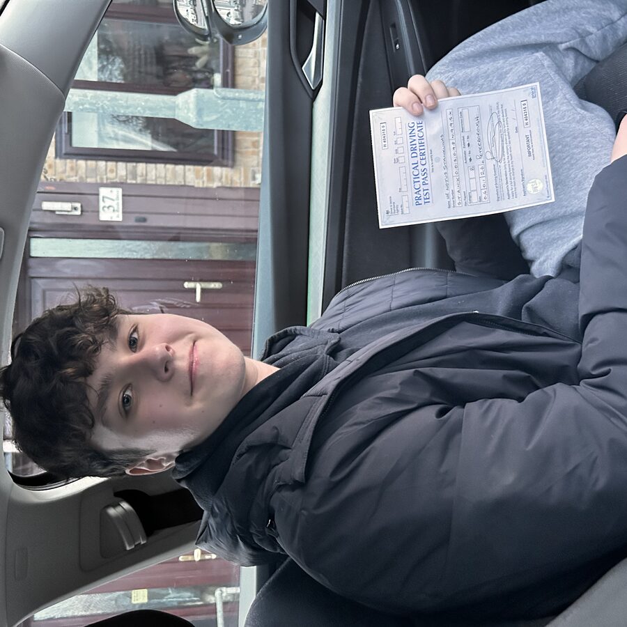 Nojus holding his practical driving test pass certificate