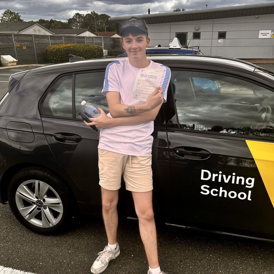 Ryan holding his practical driving test pass certificate