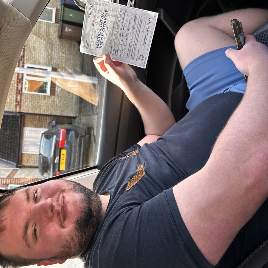 Tommy holding his practical driving test pass certificate